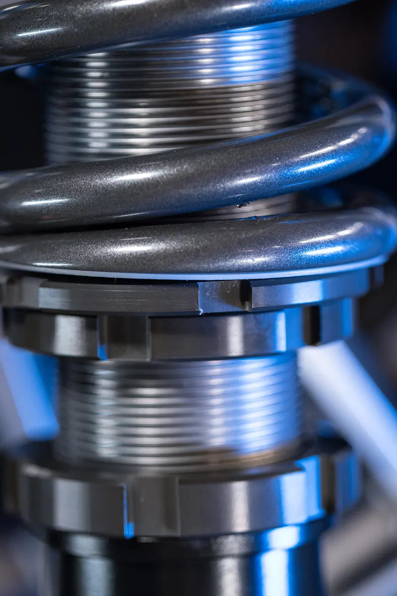 The spring seat and knurled locking collars on a Shockworks coilover, up close