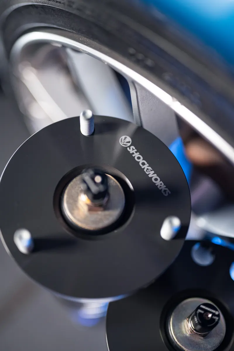 The laser-etched Shockworks logo on a black anodised coilover top mount