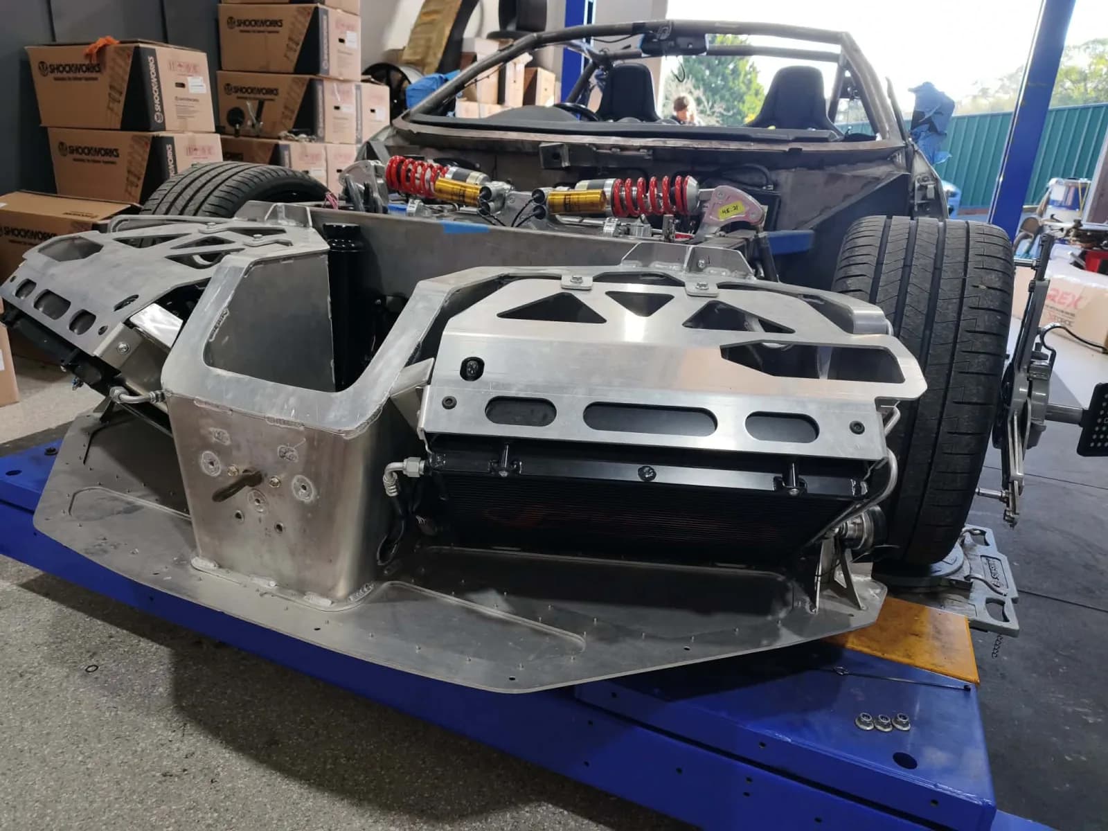 A bespoke mid-engine chassis under construction in the Monbulk workshop: aluminium tub with inboard pushrod suspension