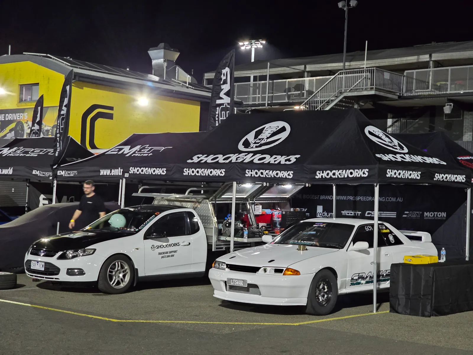 The Shockworks trackside support ute and twin Shockworks marquees set up at night in a race paddock