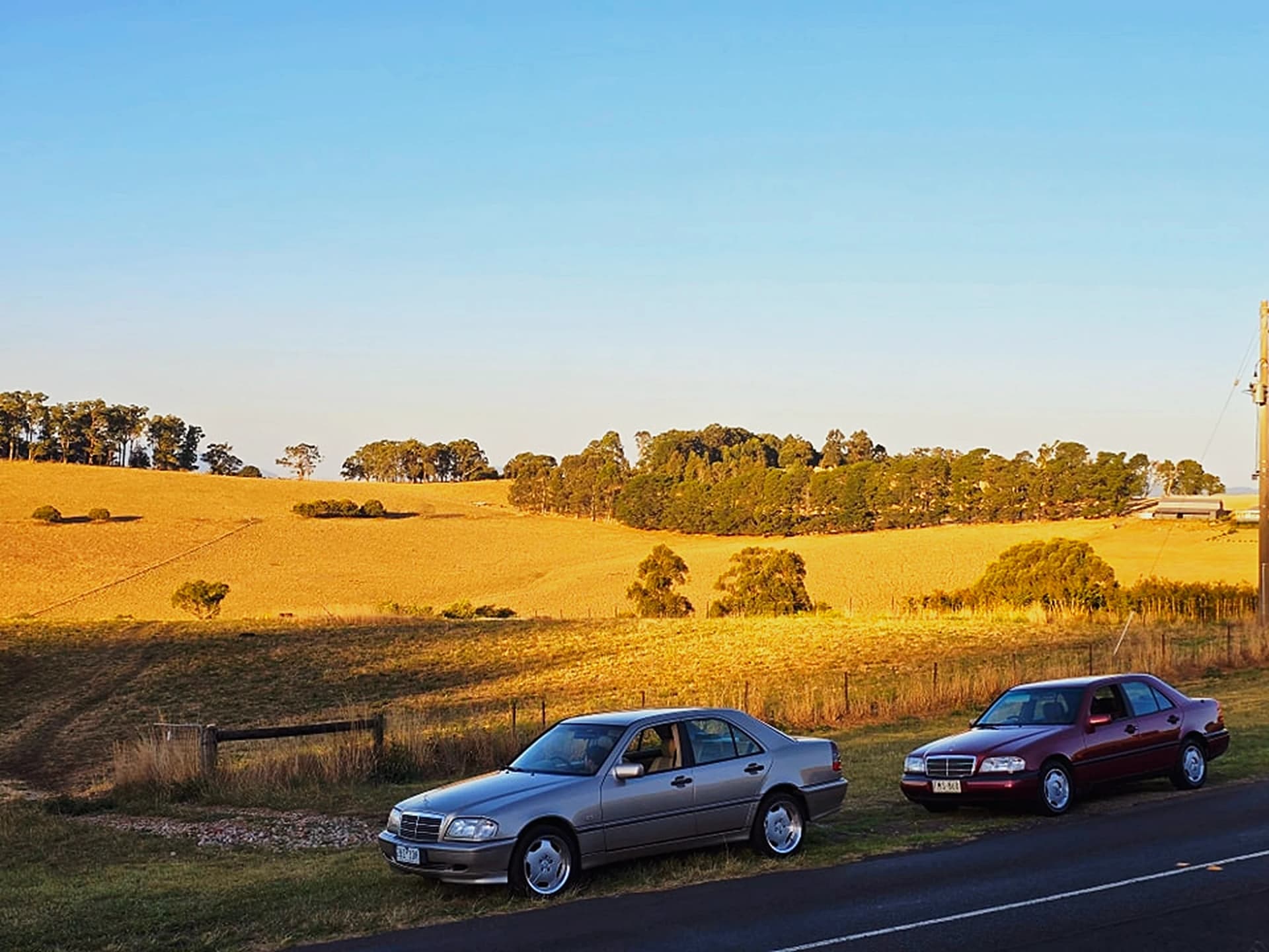 The two Shockworks loan cars, a silver and a maroon Mercedes C-Class, parked on a country road